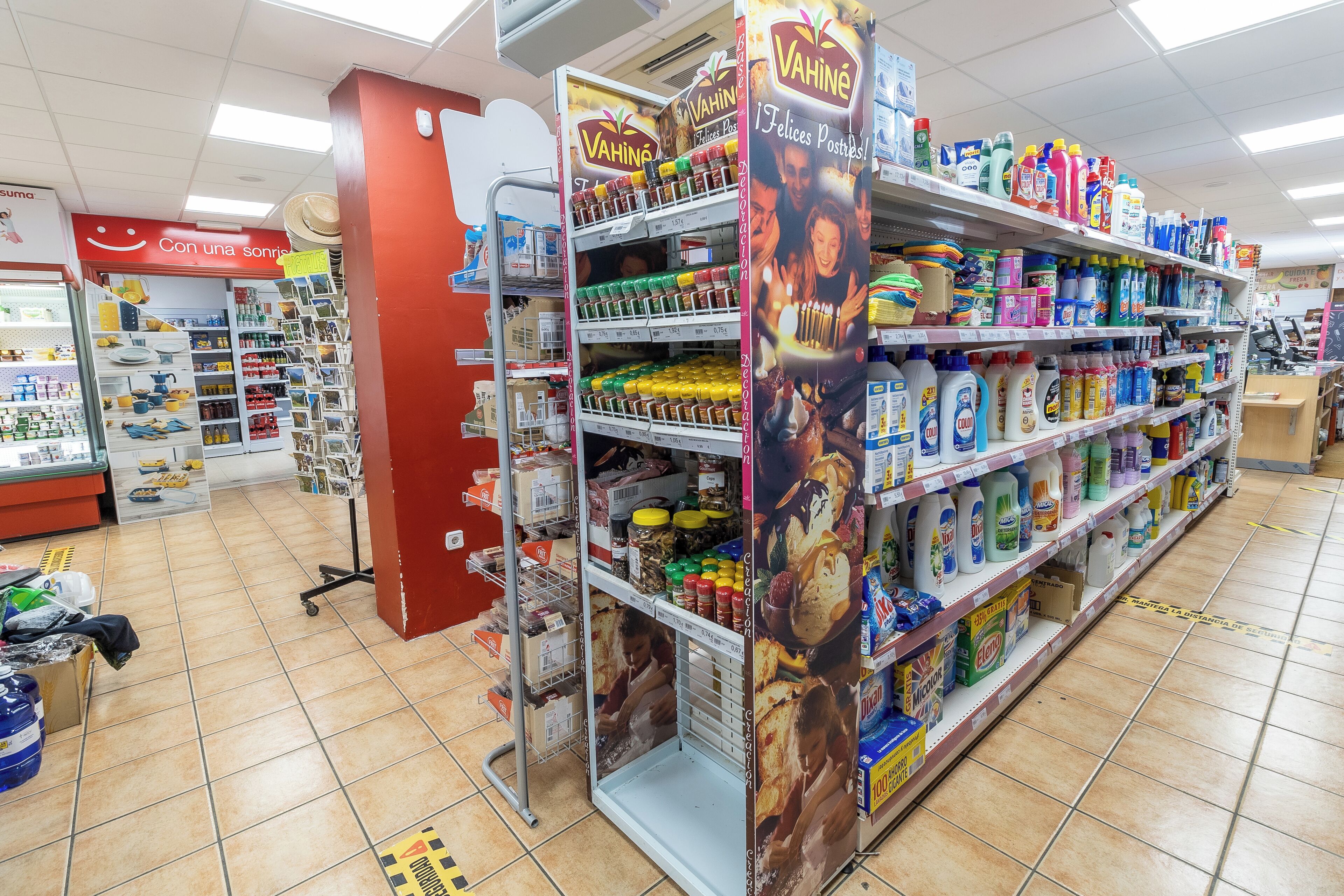 Pasillo de un supermercado con estantes llenos de diversos productos del hogar.