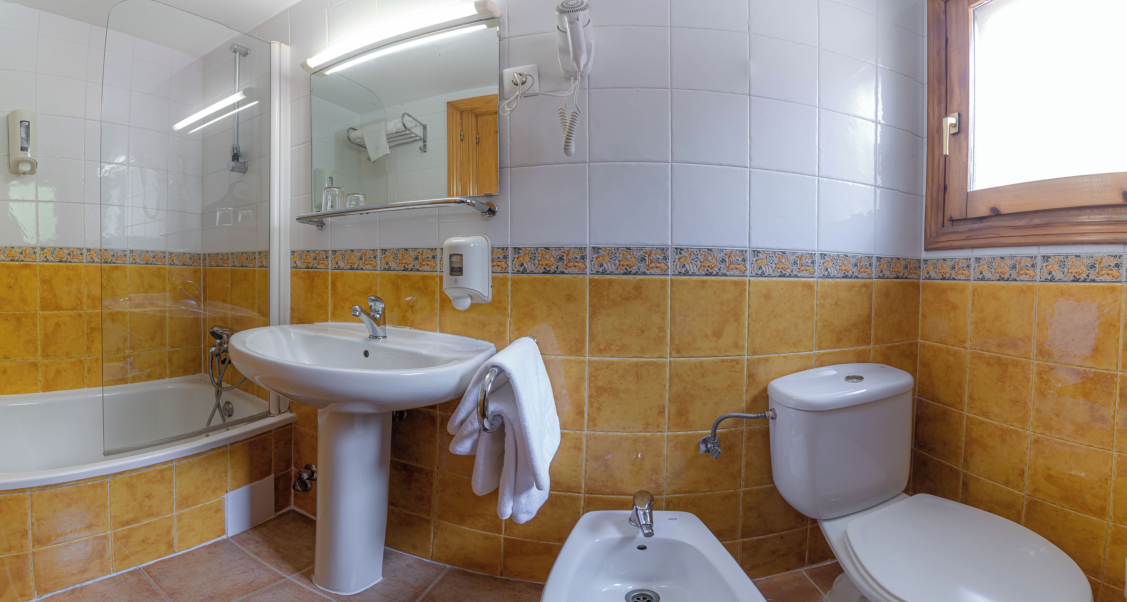 A bathroom with a bathtub, sink, toilet, and a mirror.