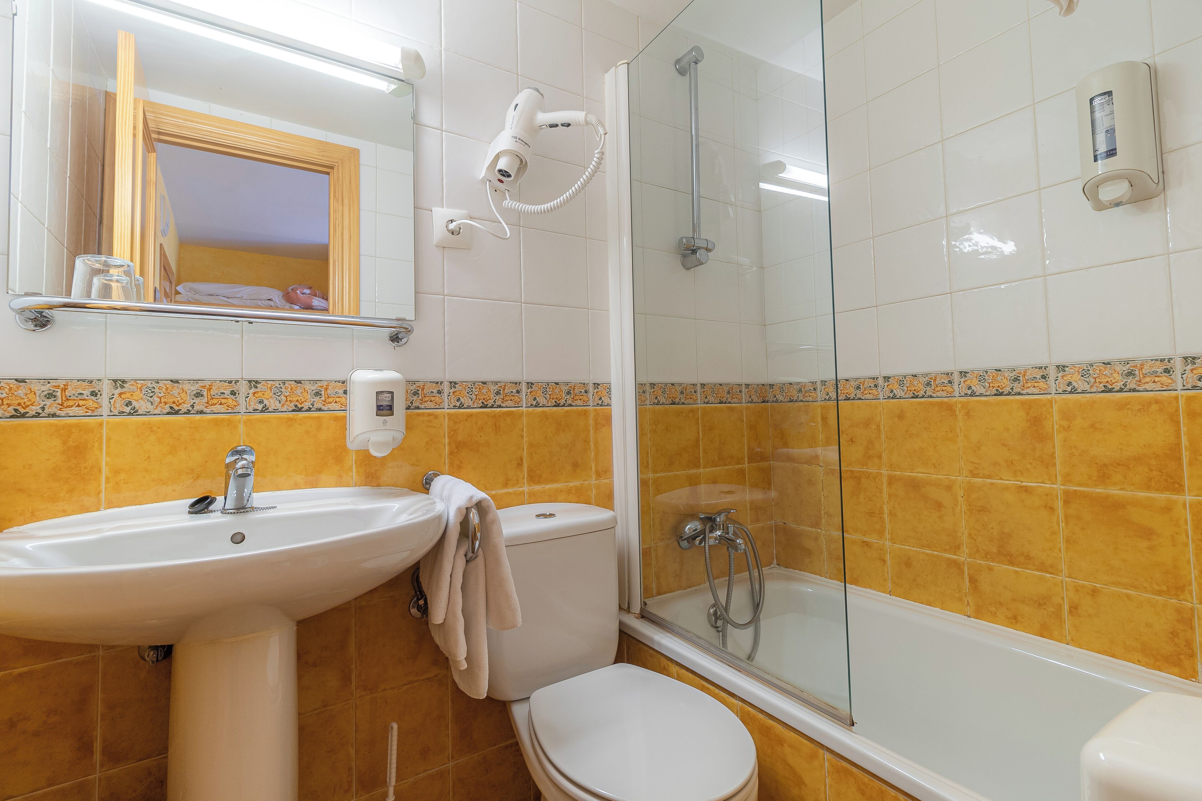A bathroom with a sink, toilet, and shower.