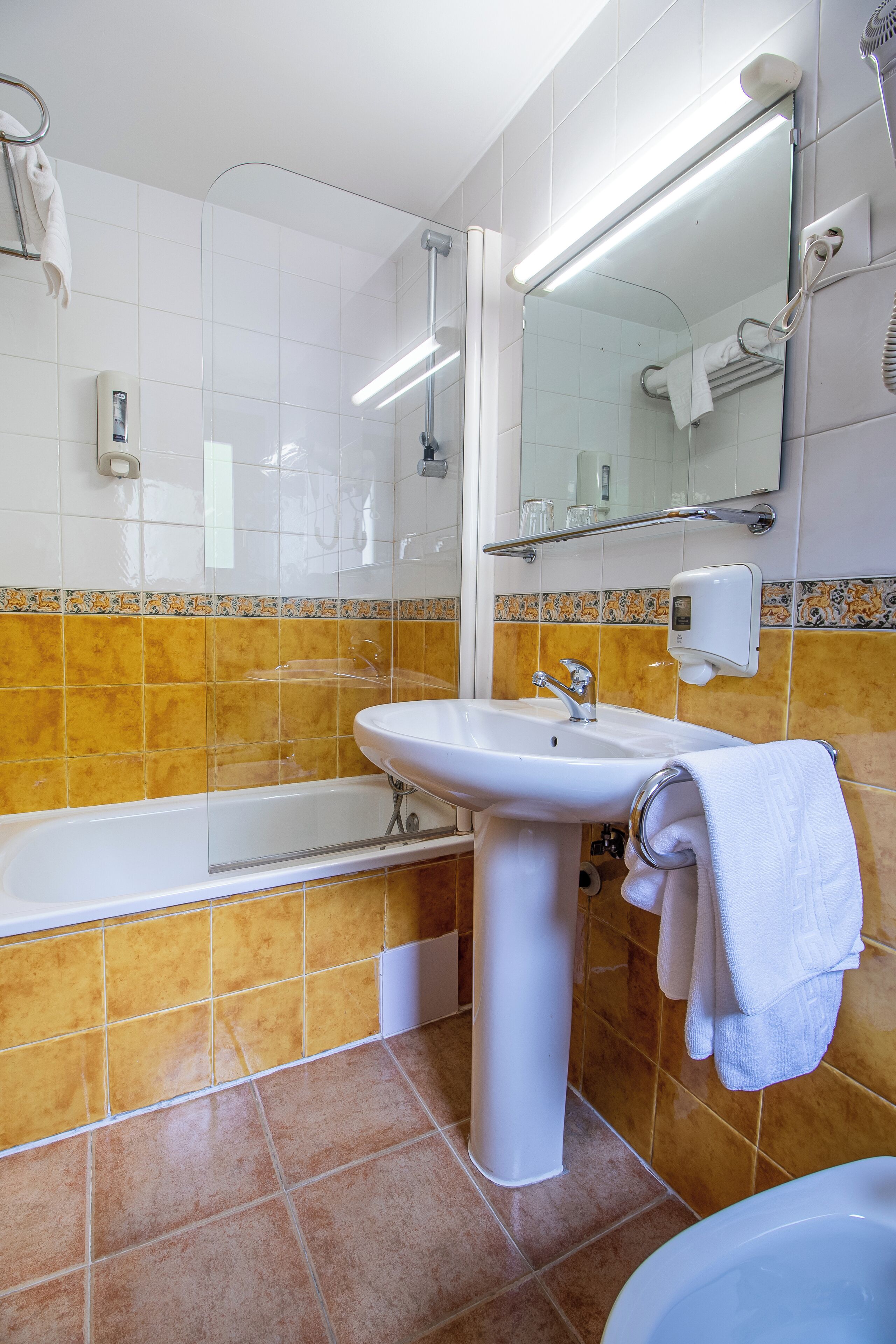Une salle de bain avec un lavabo blanc, une baignoire et une douche.