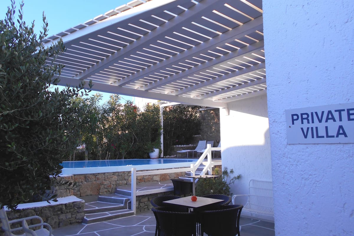 Une villa privée dotée d’un espace extérieur aménagé, d’une piscine et d’une pergola.