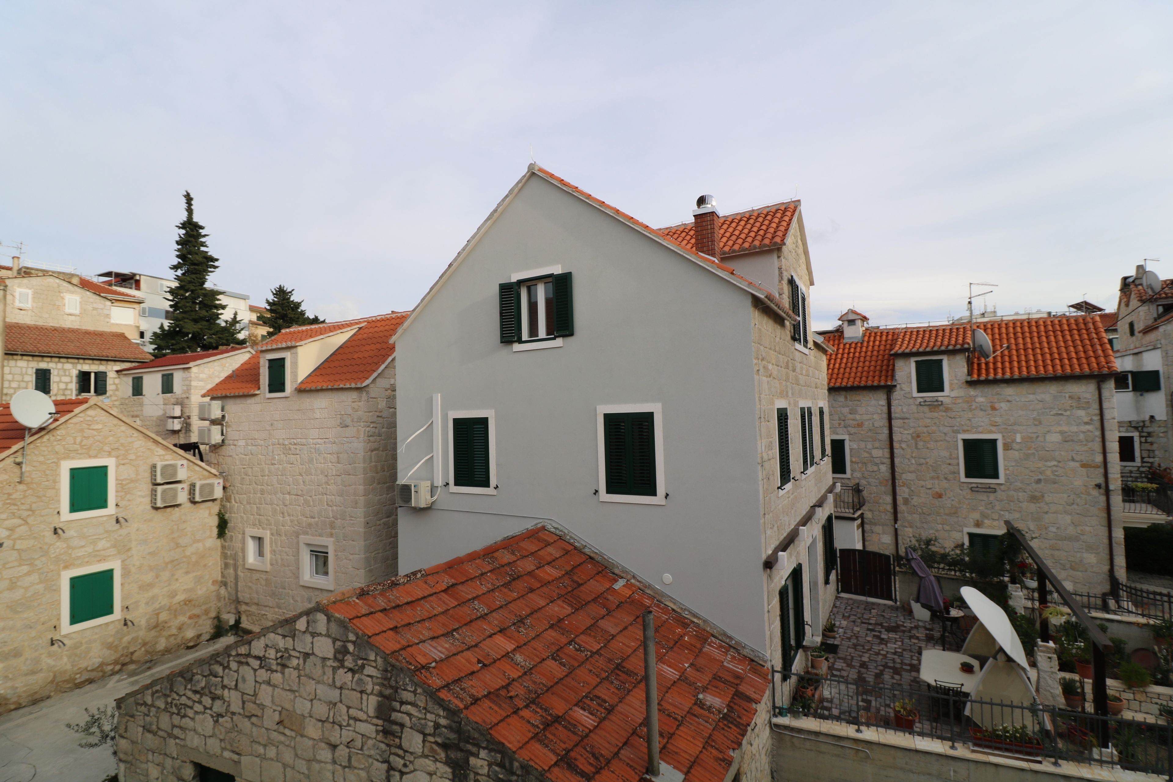 A multi-story building with stone walls and red-tiled roofs.