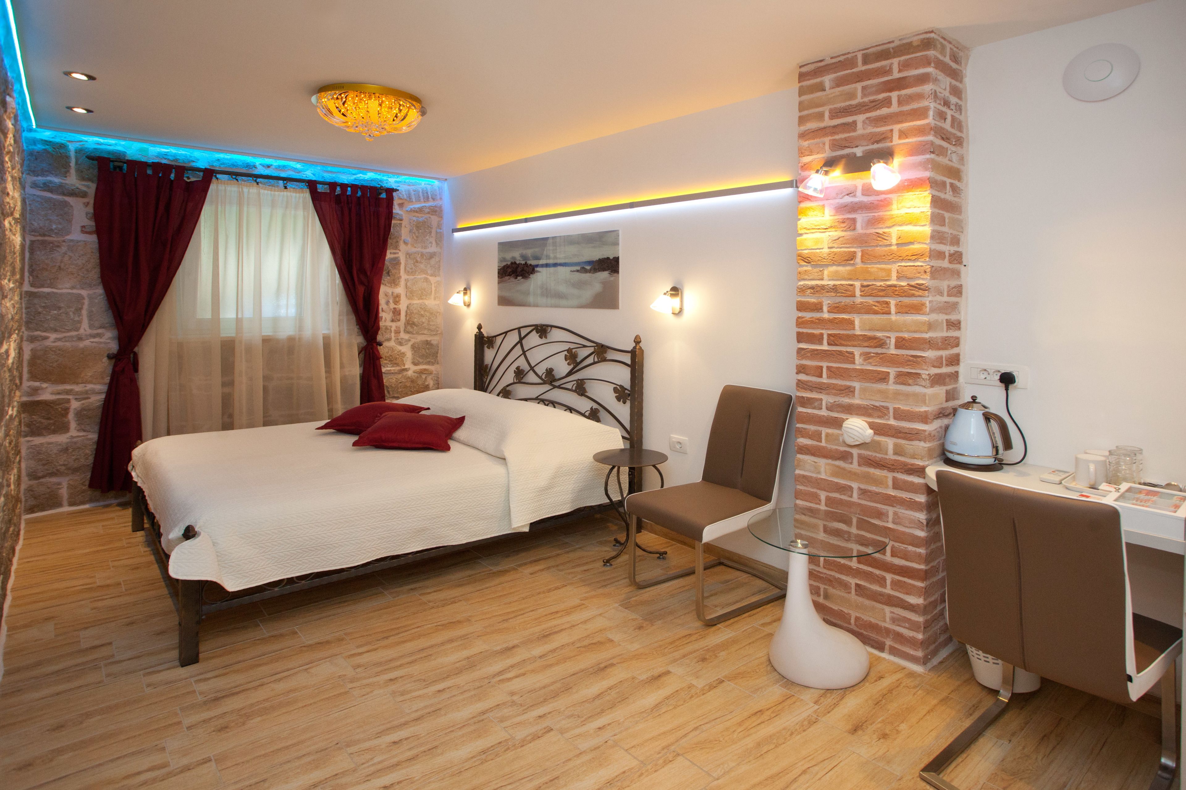 A bedroom with a bed, a desk, and a chair.