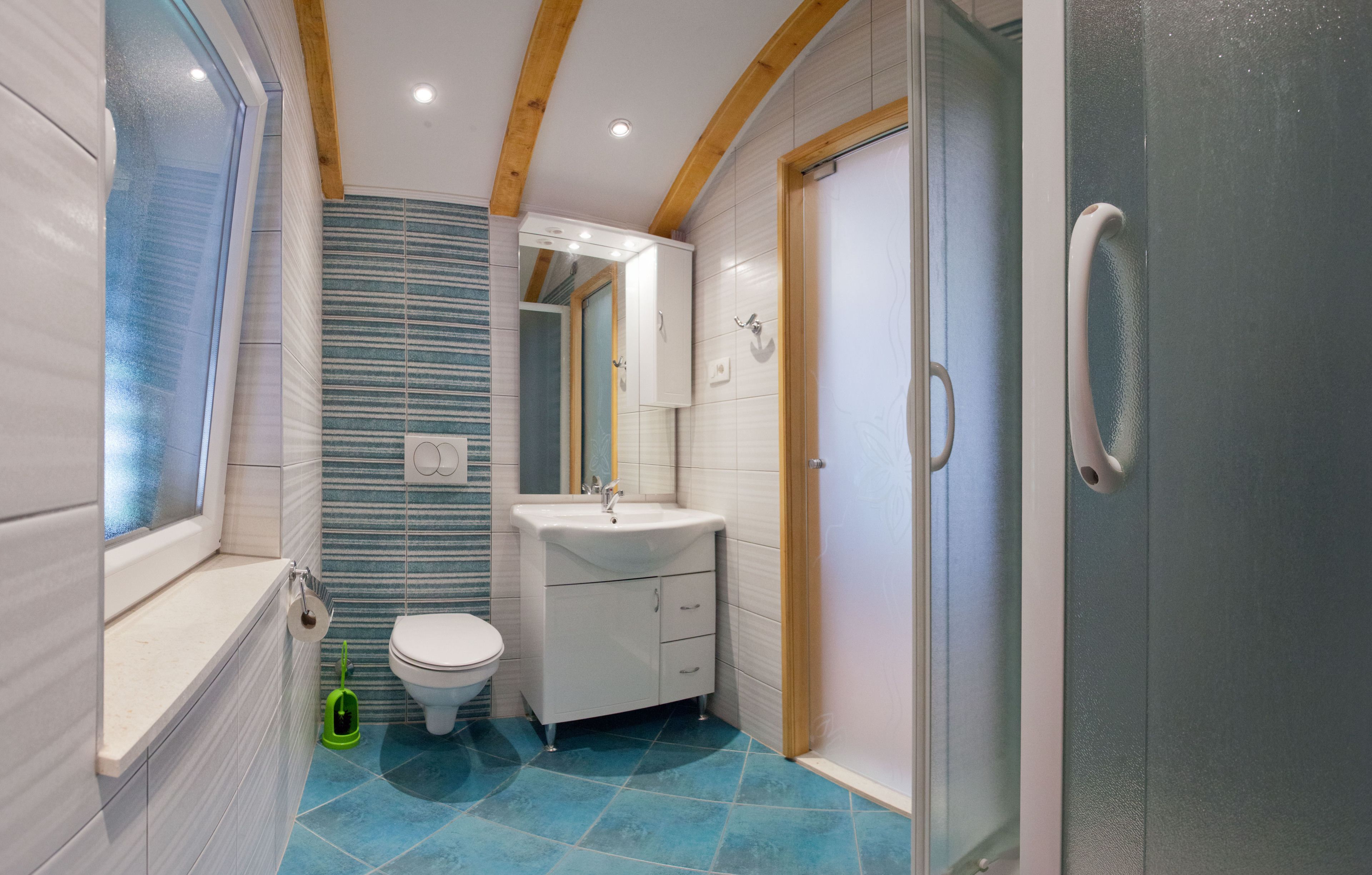 A bathroom with a toilet, sink, and shower.