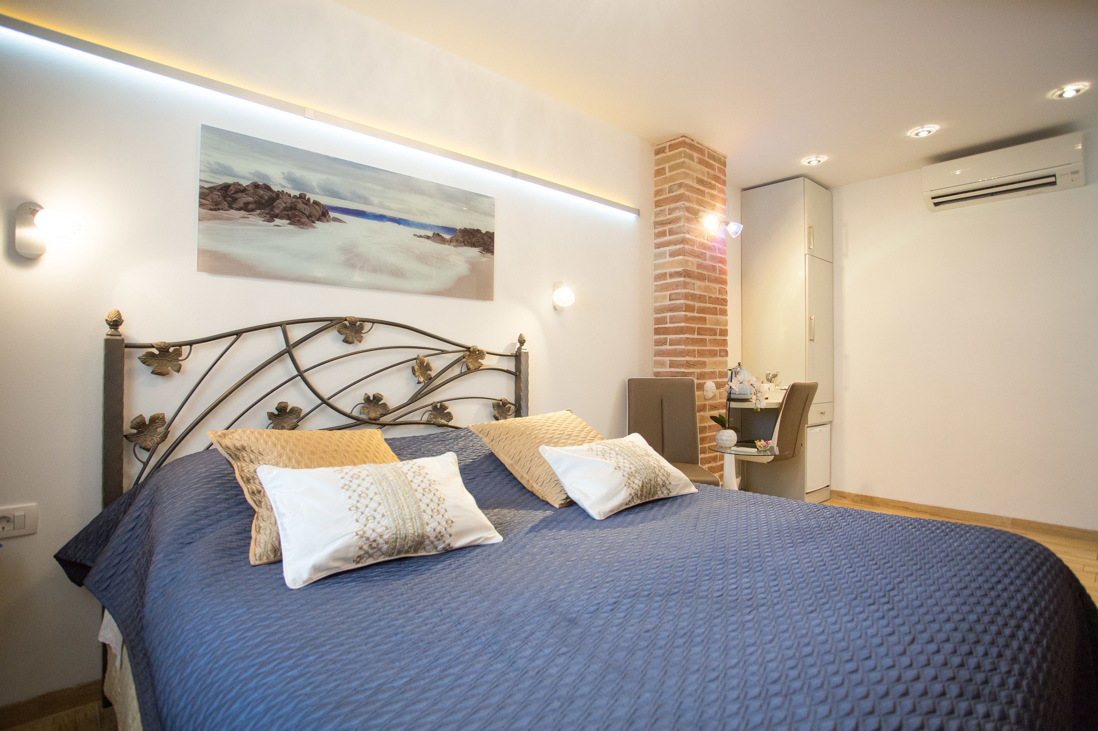 A bedroom with a bed, a desk, and a chair.