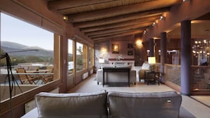 Amplia sala de estar con un ventanal grande, un sofá, una mesa de comedor y una zona de cocina.