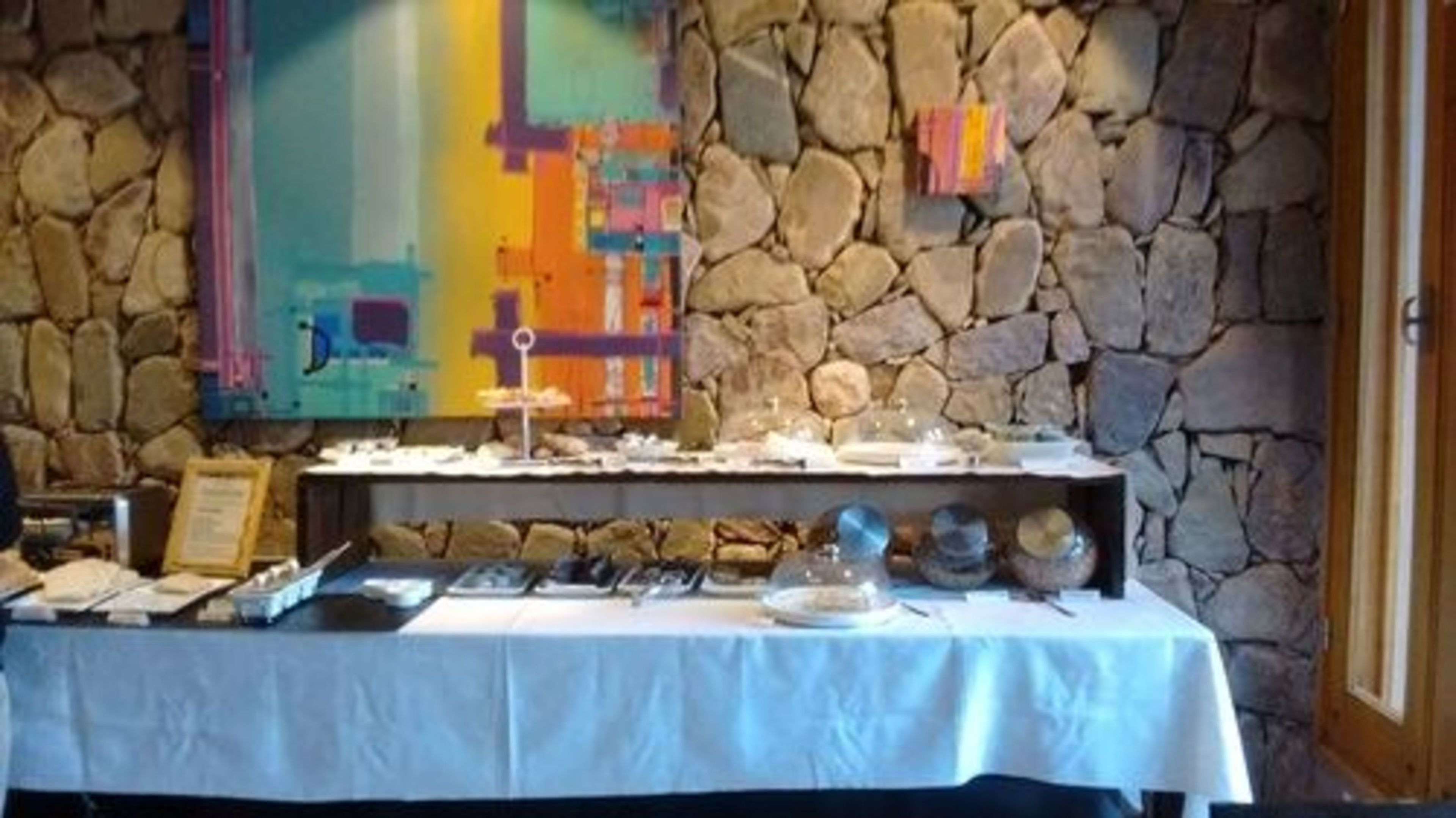 A buffet table with various dishes and a stone wall backdrop.