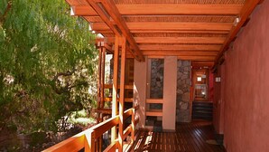 Una terraza de madera con un muro de piedra y barandilla de madera.