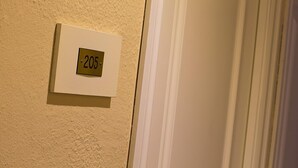 A white door with a number plate indicating room number 205. - Hostal Casa Salvador (Granada)