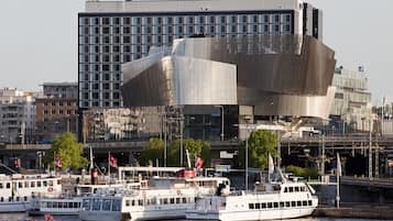 A modern building with a unique angular design, surrounded by water and boats.