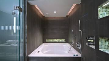 A modern bathroom with a freestanding bathtub, a glass shower enclosure, and a tiled backsplash.