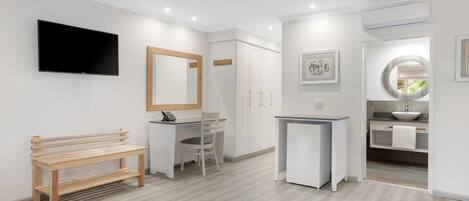 Un baño moderno con lavamanos, espejo e inodoro.