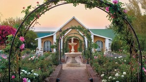 A garden with a central fountain, surrounded by a brick pathway and lush greenery. - Protea Hotel by Marriott Polokwane Ranch Resort (Polokwane)