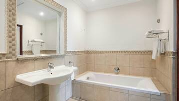 A bathroom with a sink, a mirror, and a bathtub.