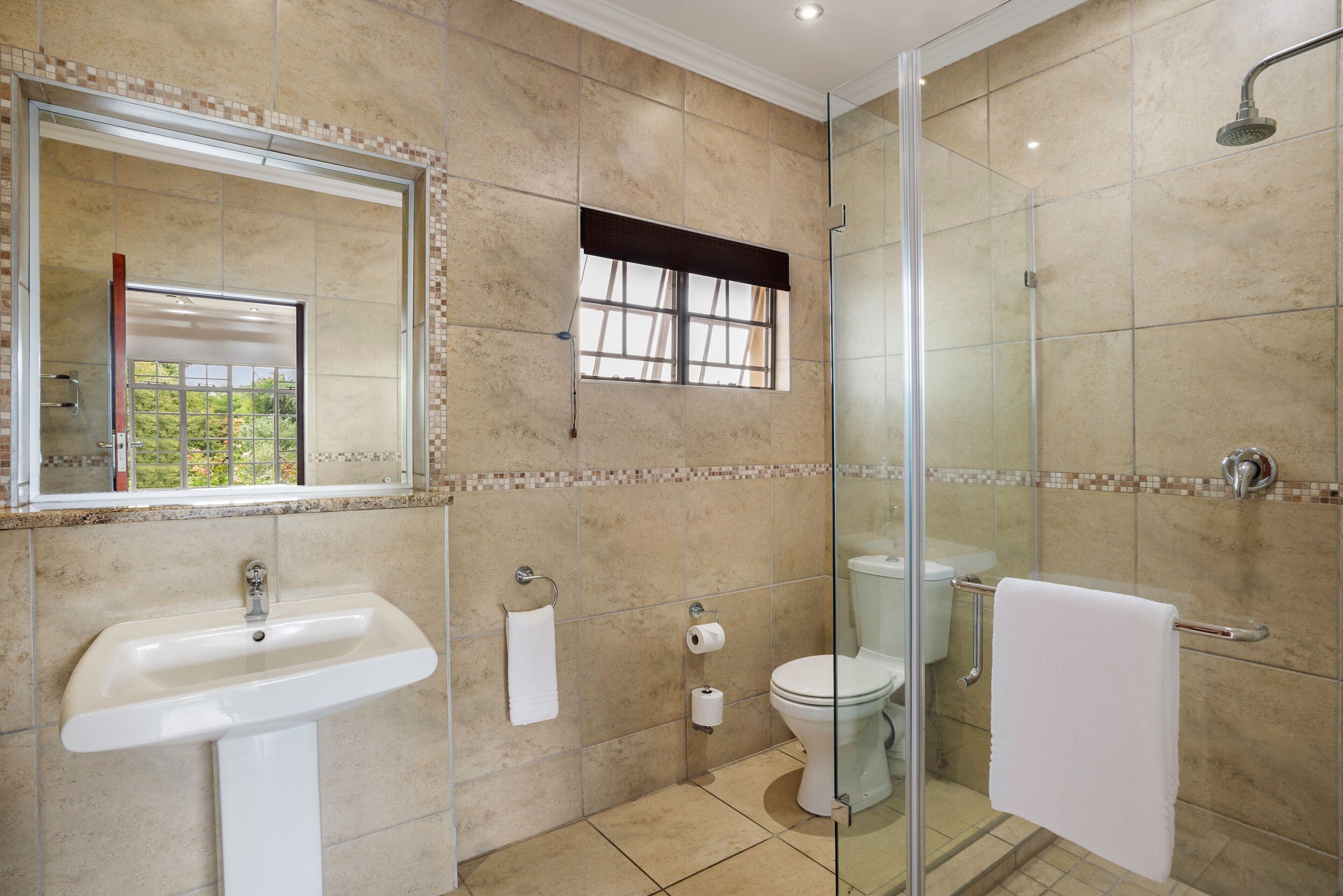 A bathroom with a sink, toilet, and shower.