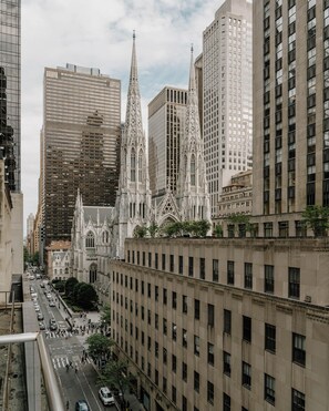 A cityscape with modern high-rise buildings and a historic cathedral with intricate spires.