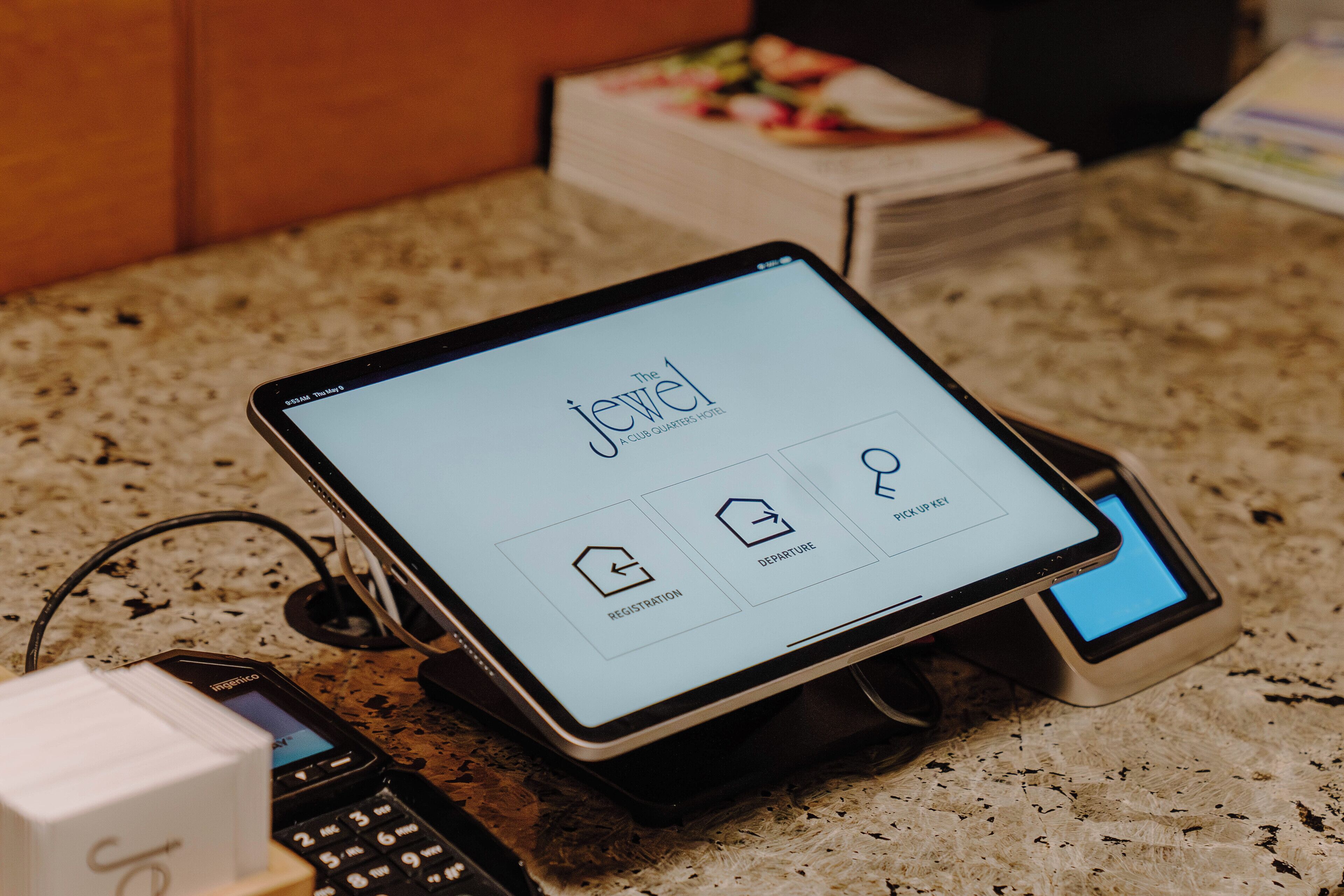 A tablet displaying a hotel booking interface with options for registration and departure.