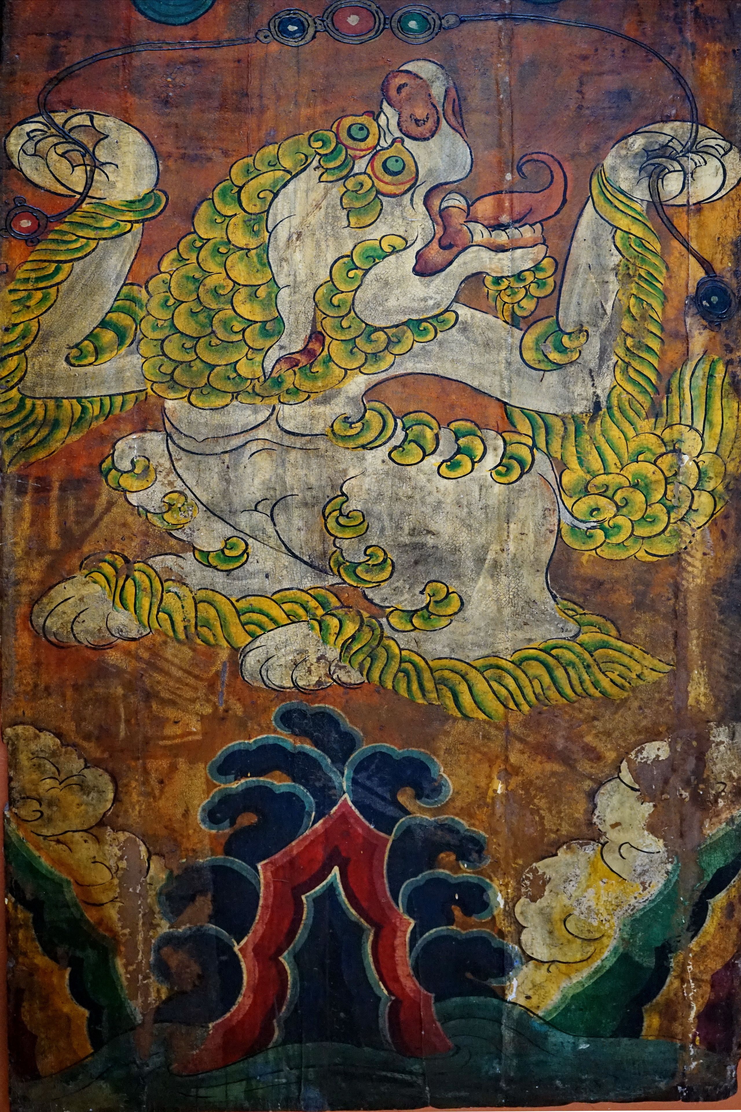 A detailed mural with a central figure surrounded by ornate patterns and smaller figures.
