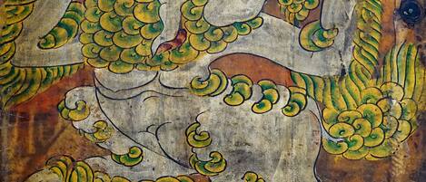 A detailed mural with a central figure surrounded by ornate patterns and smaller figures.