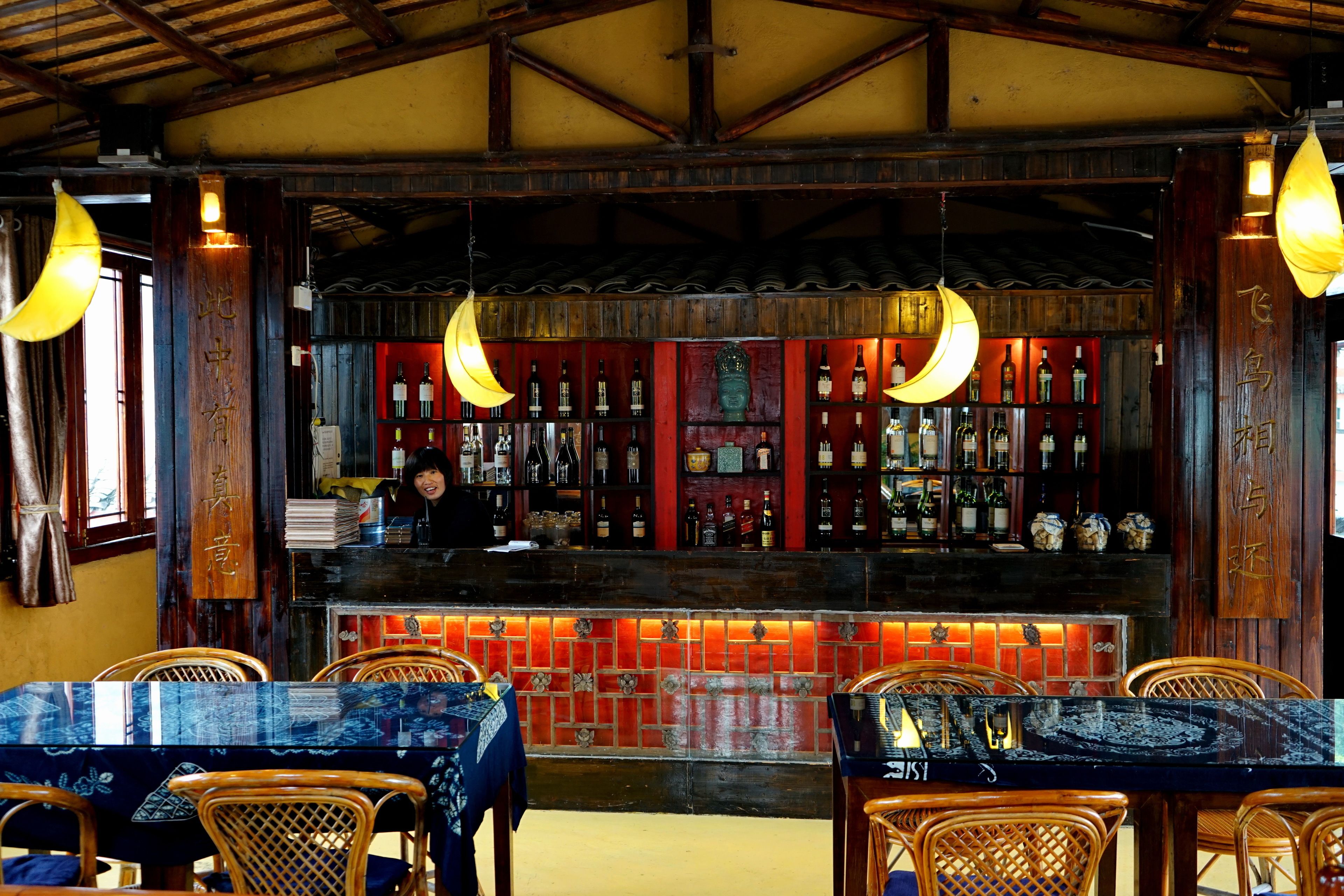 A bar area with wooden furniture and hanging light fixtures.