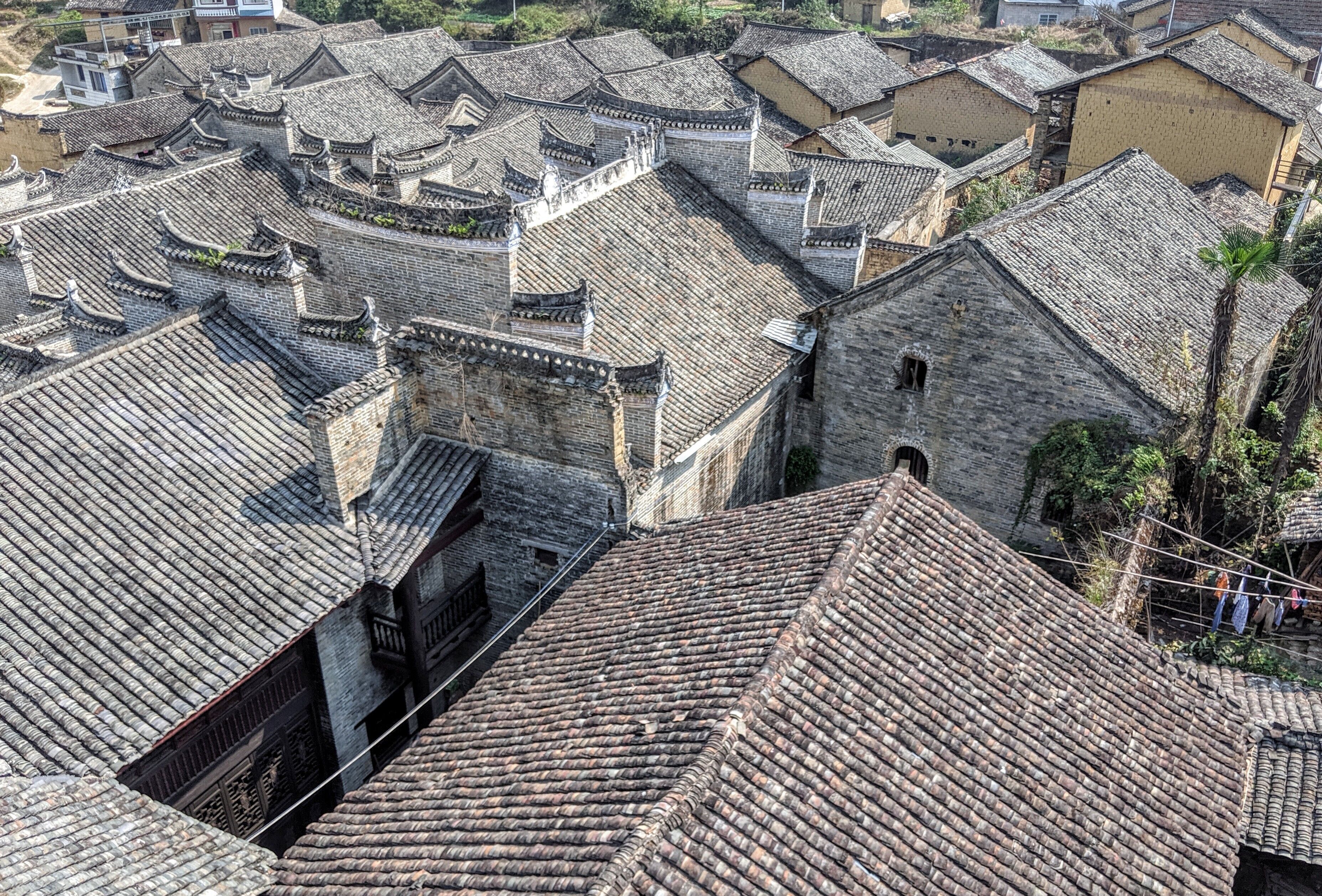 A traditional Chinese courtyard with tiled roofs and stone walls.