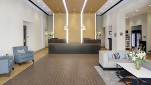 A spacious lobby with a reception desk, seating area, and a visible refrigerator in the background. - HYATT house San Jose/Silicon Valley (San Jose)