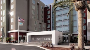 A multi-story hotel with a prominent 'Hyatt House' sign, a flag, and a palm tree. - HYATT house San Jose/Silicon Valley (San Jose)