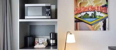 Habitación de hotel con microondas, cafetera y un letrero de San Jose Bar & Grill.