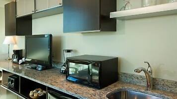 A modern kitchen with a built-in microwave, a coffee maker, and a sink.