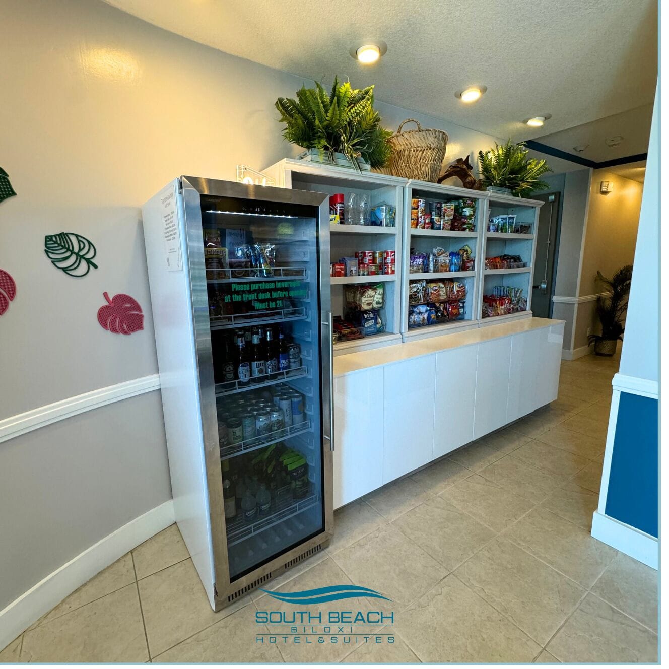 A hotel lobby with a self-service beverage station, a reception desk, and a buffet area.