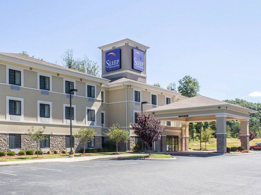 Un bâtiment de la chaîne Sleep Inn & Suites doté d’une entrée abritée, d’une façade en pierre et de nombreuses fenêtres.
