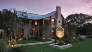 A two-story building with a metal roof and a sign reading "Inn on Lake Granbury." - Inn on Lake Granbury a Boutique Hotel (Granbury)