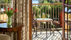 A balcony with a table and chairs, a vase with red tulips, and a view of a lake and mountains. - Inn on Lake Granbury a Boutique Hotel (Granbury)
