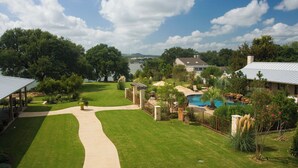 A residential property with a swimming pool, a well-maintained lawn, and a view of a lake. - Inn on Lake Granbury a Boutique Hotel (Granbury)