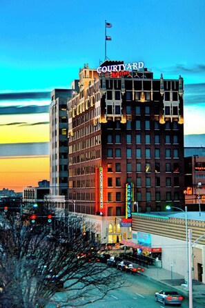 A multi-story hotel with a prominent 'Courtyard' sign, featuring a classic architectural style with a flat roof and large windows. - Courtyard by Marriott Amarillo Downtown (Amarillo)