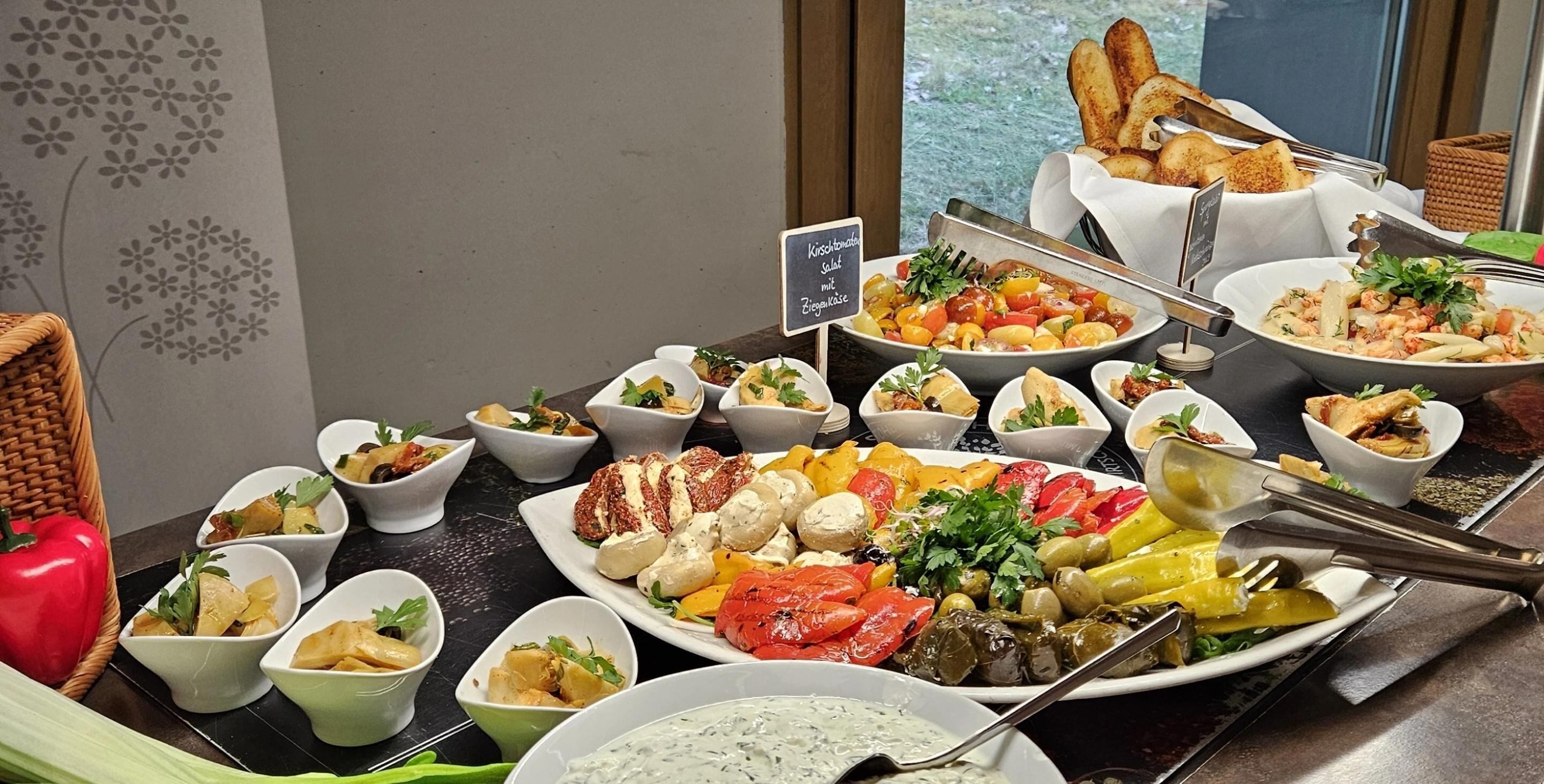A buffet with various dishes including salads, grilled vegetables, and seafood.