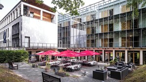 A modern building with outdoor seating and a patio area. - Ringhotel Schorfheide I Waldresort Werbellinsee (Joachimsthal)