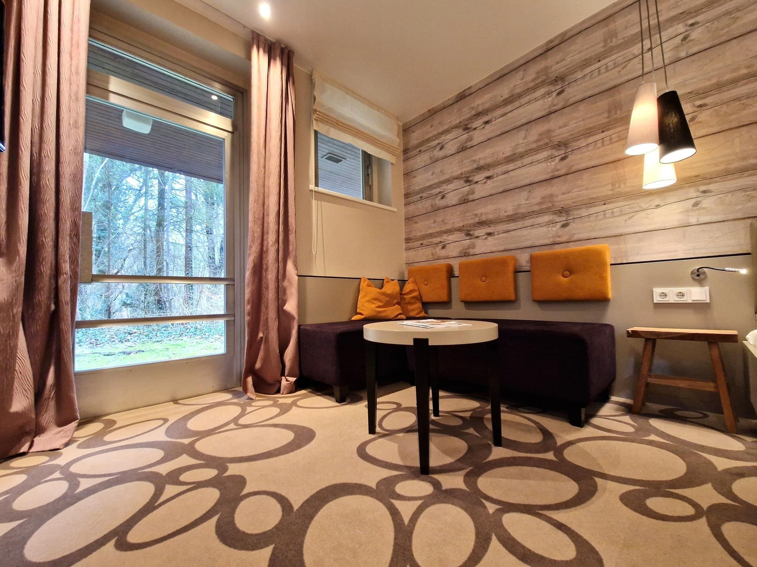 Ein modernes Zimmer mit einer Couch, einem runden Tisch und einer Wand mit Holzverkleidung.