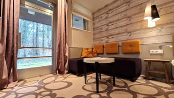 A modern room with a sofa, a round table, and a wooden accent wall.