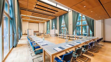 A conference room with a long table, chairs, and a whiteboard.