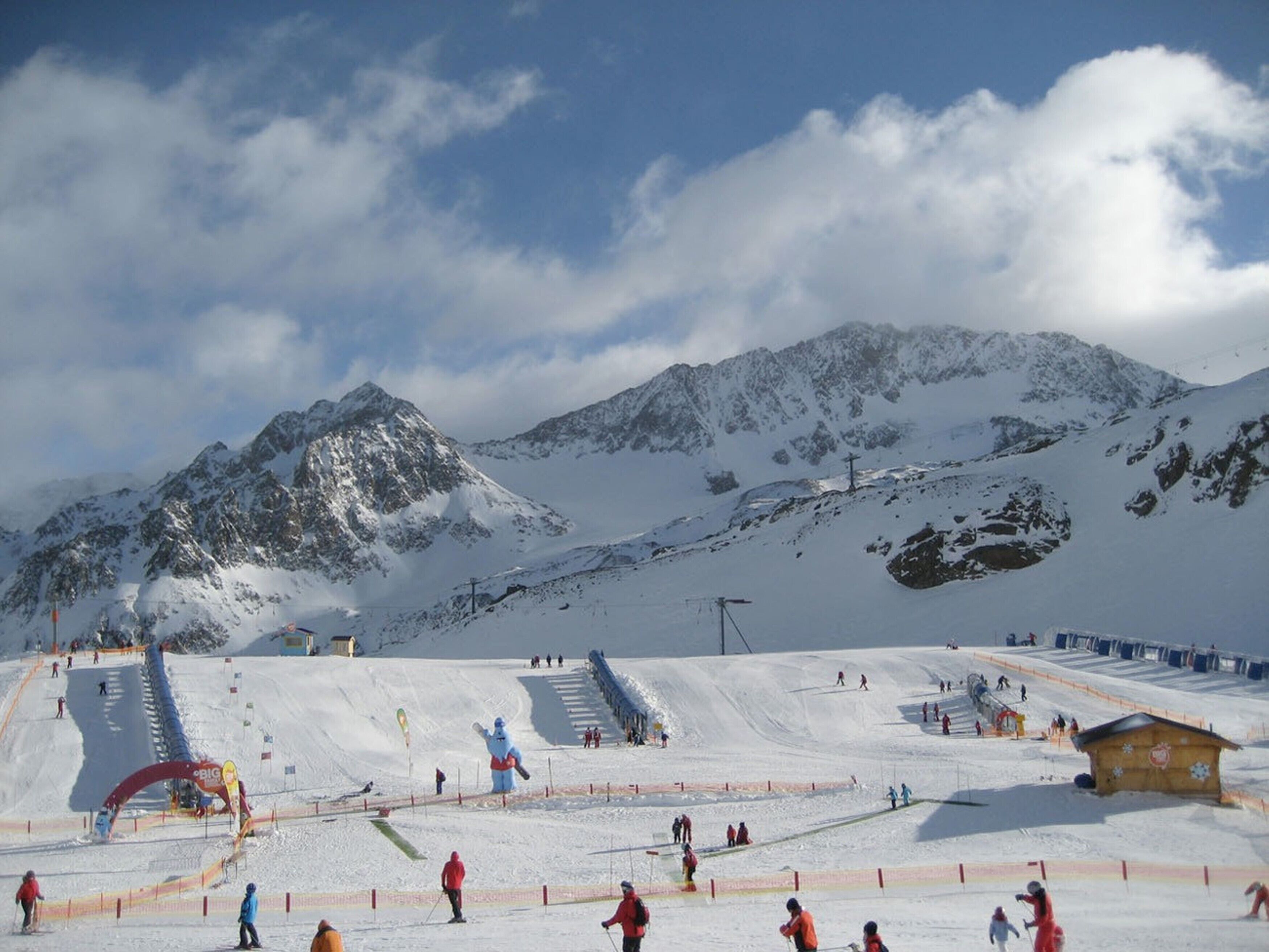 A ski resort with a chairlift, ski slopes, and a mountain backdrop.