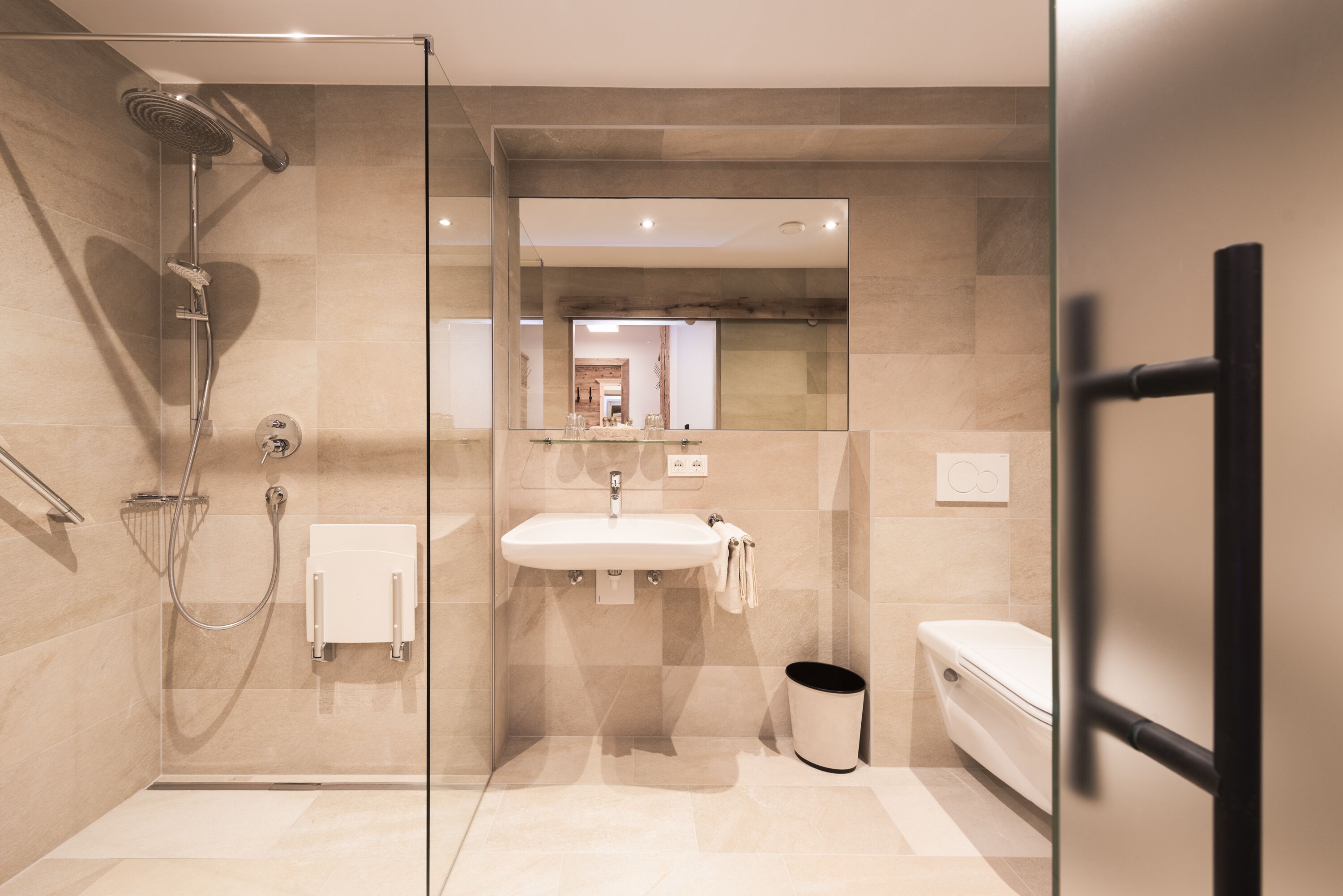 Un baño moderno con ducha acristalada, lavabo blanco y retrete.