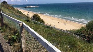 A coastal view with a beach, a pier, and a fence overlooking the ocean. - The Kensington Hotel (Bournemouth)