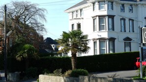 A two-story building with a white facade, large windows, and a corner bay window. - The Kensington Hotel (Bournemouth)