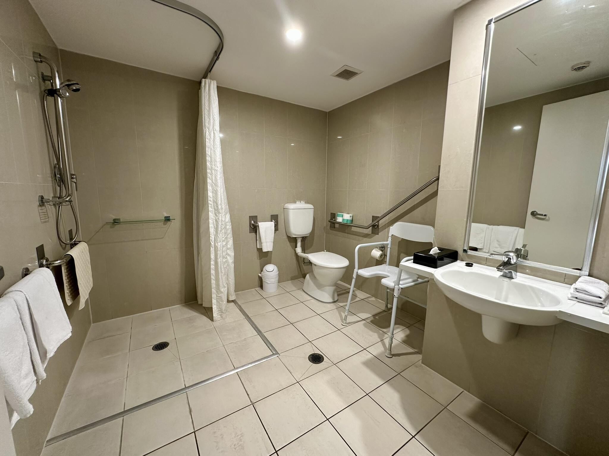 Une salle de bain moderne équipée d’une douche, de toilettes, d’un bidet et d’un lavabo.