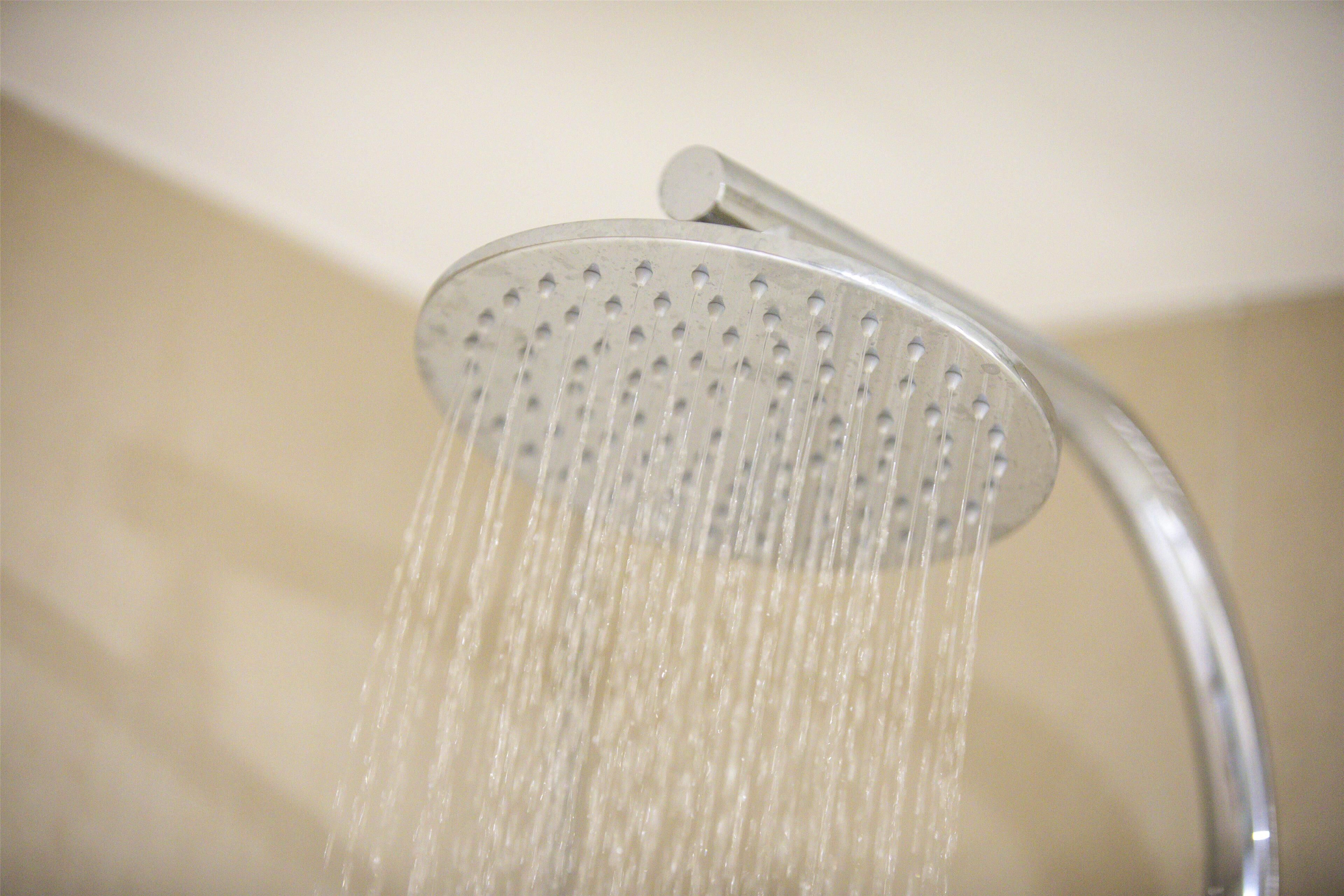 A showerhead with water flowing from it.