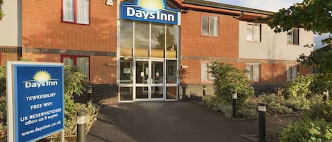A Days Inn building with a clear entrance, a signboard, and a brick facade.