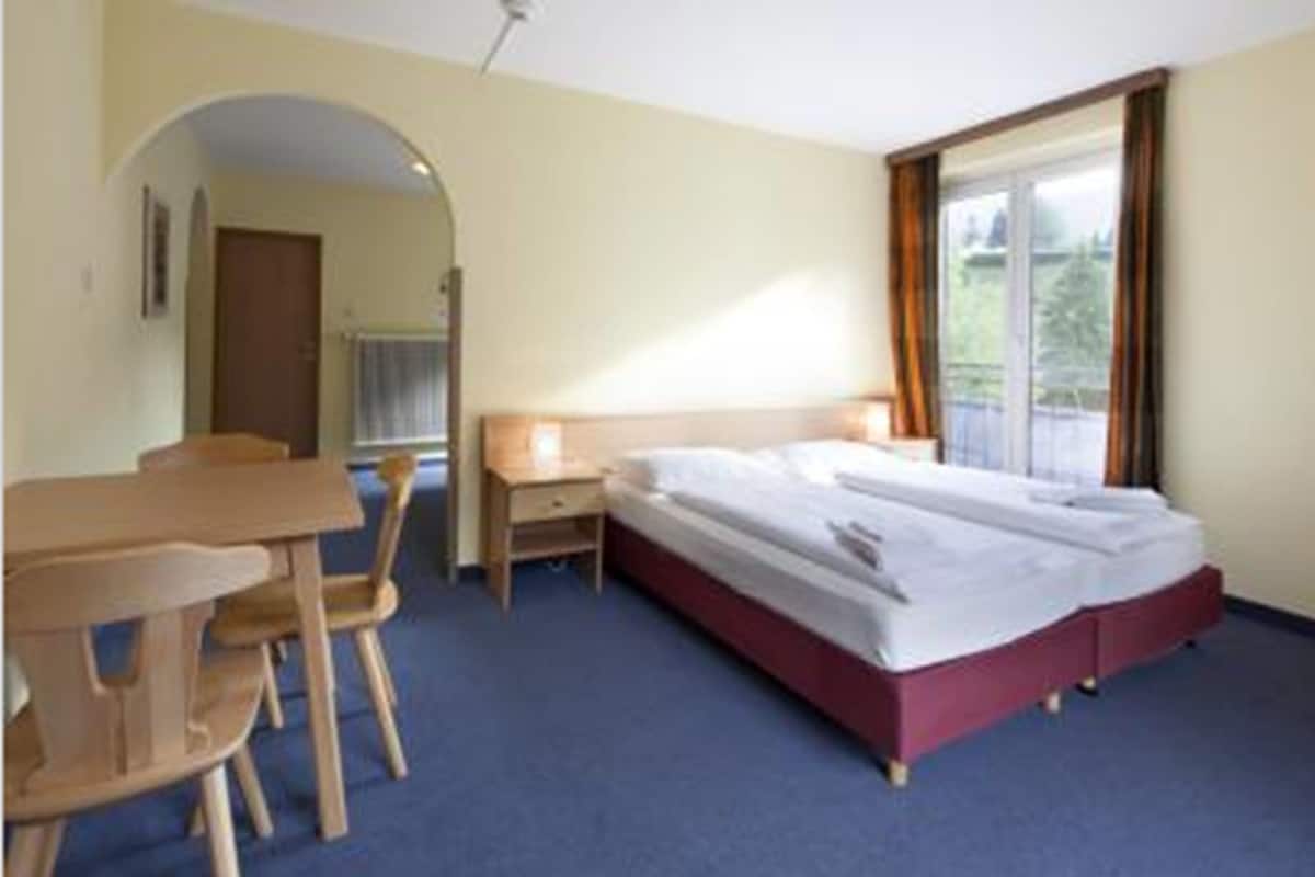 Een hotelkamer met een bed, een bureau en een stoel.