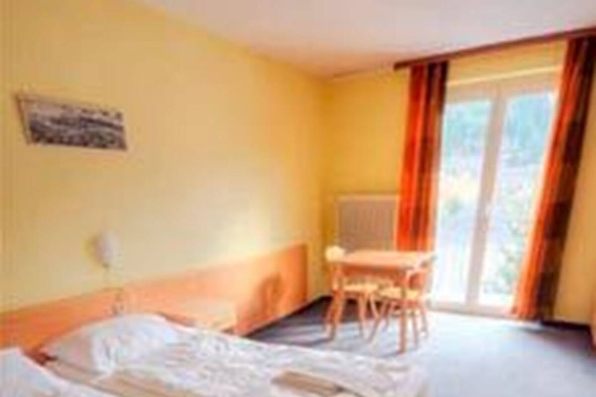 Une chambre d’hôtel avec deux lits, un bureau et une fenêtre avec des rideaux.