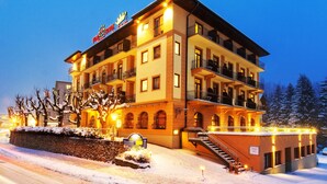 Un hotel de varios pisos con balcones, una escalera y un paisaje cubierto de nieve.